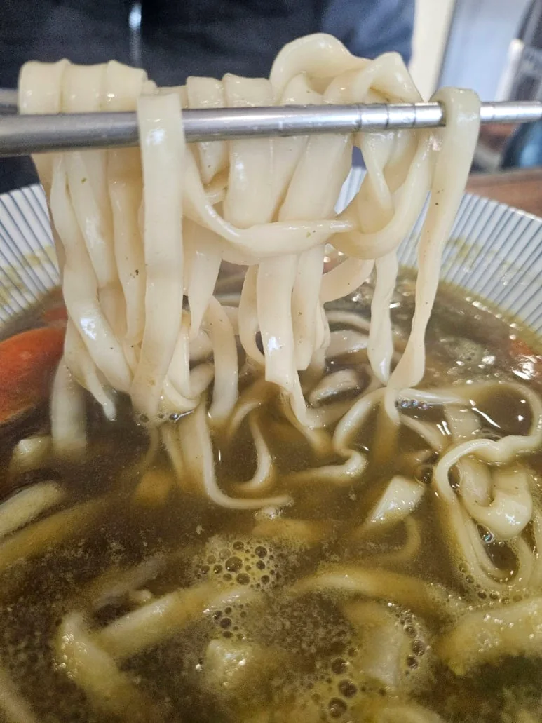 젓가락으로 들어 올린 쫄깃한 칼국수 면